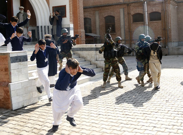 Schoolchildren flee as army soldiers conducting an exercise to repel militant attacks detain a mock-militant (R) at the Islamia Collegiate School in Peshawar, Pakistan February 02, 2016. PHOTO: REUTERS
