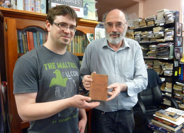 This handout photo taken and received on May 10, 2016 by Cracked and Spineless New and Used Books shows bookshop owners Richard Sprent (L) and Mike Gray (L) with the diary of British Lieutenant-Colonel John Squire, who served with the Duke of Wellington, which was discovered among a pile of books in a cupboard at the Cracked and Spineless New and Used Bookstore in the Tasmanian capital Hobart. PHOTO: AFP