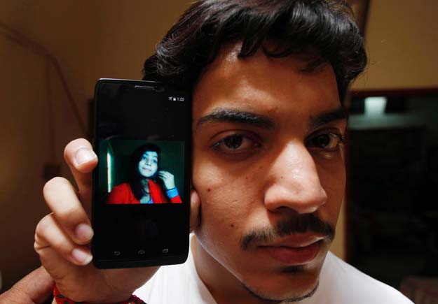 Hassan Khan shows the picture of his wife Zeenat Bibi, who was burnt alive by her mother, on his cellphone at his residence in Lahore on June 8, 2016. PHOTO: AFP