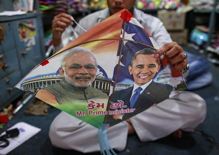 An employee ties threads on a kite, with portraits of Indian Prime Minister Narendra Modi (L) and US President Barack Obama, ahead of Obama's visit, in Mumbai. PHOTO: REUTERS