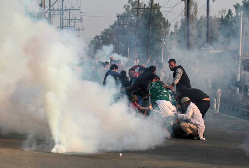 Kashmiri mourners hold the body of Junaid Ahmad, 12, as they are fired on with tear gas by Indian police during his funeral procession in downtown Srinagar on October 8, 2016. PHOTO: AFP