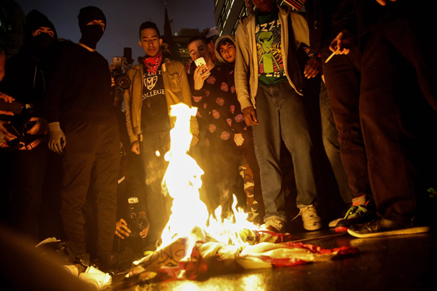 Protesters burn an American flag on Fifth Avenue outside of Trump Tower, November 9, 2016 in New York City. PHOTO: AFP
