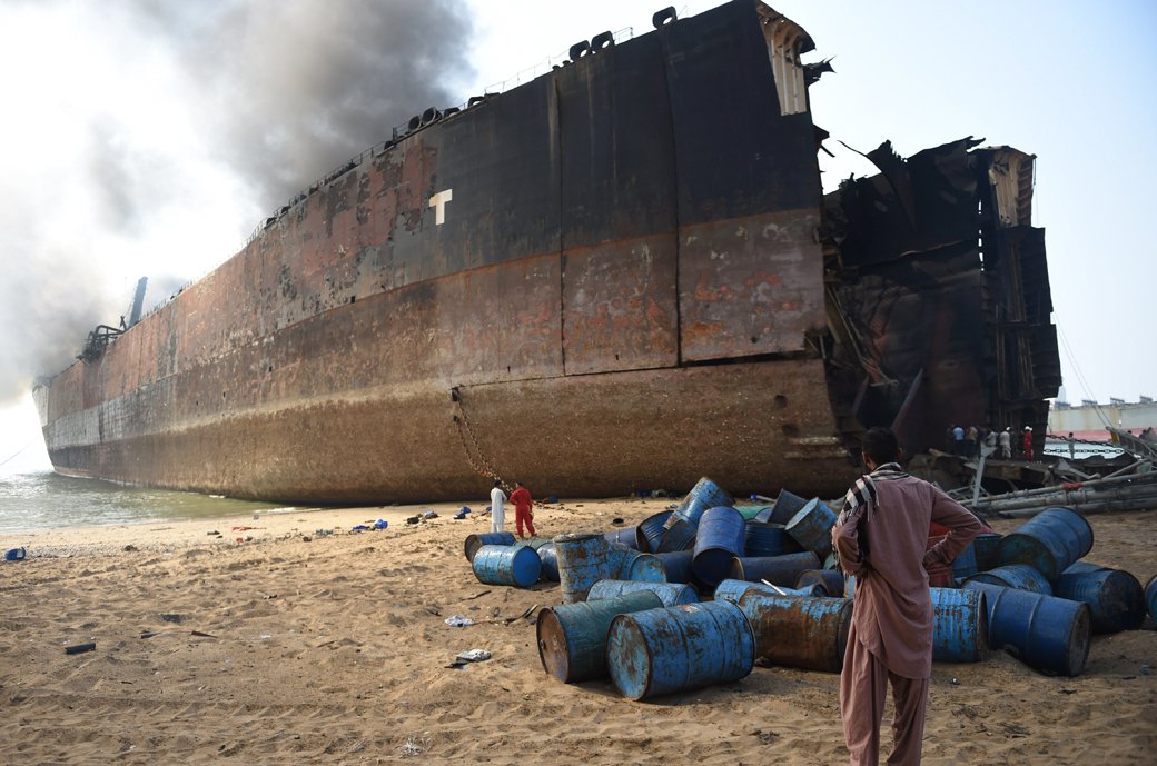 A man looks at the wreckage of a burning ship a day after a gas cylinder explosion at the Gadani shipbreaking yard on November 2, 2016. PHOTO: AFP