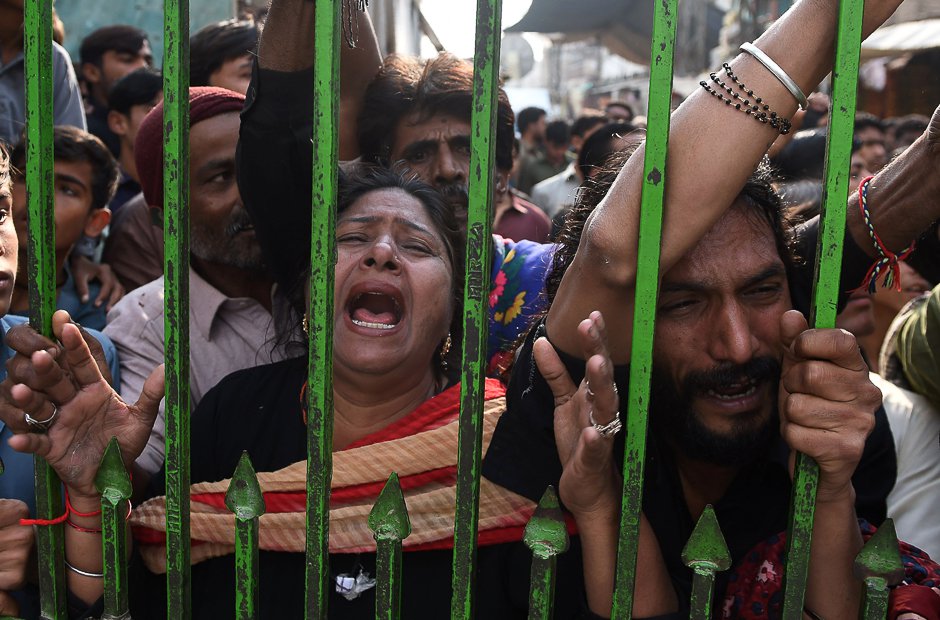 Devotees gather outside closed gate of Lal Shahbaz Qalandar shrine after a suicide attack killed over 80 people. PHOTO: AFP