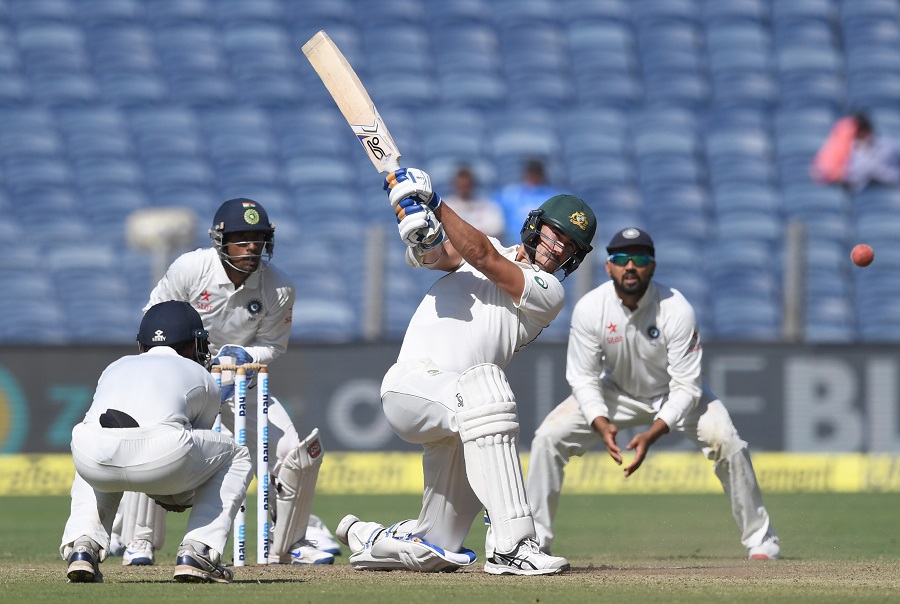 Australia's Mitchell Starc plays a shot as India's Ajinkya Rahane (L), Wriddhiman Saha (2L) and Murali Vijay (R) look on during the first day of the first Test cricket match between India and Australia at the Maharashtra Cricket Association stadium in Pune on February 23, 2017. PHOTO: AFP