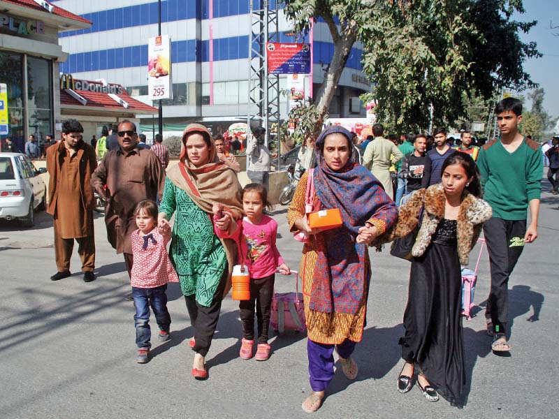 Families leave a market after hearing rumours of another blast in Gulberg on Thursday. PHOTO: ABID NAWAZ/EXPRESS