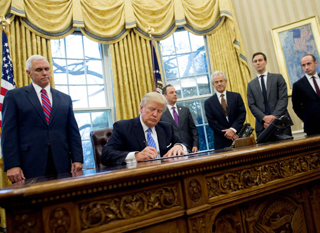 This file photo taken on January 23, 2017 shows US President Donald Trump signing an executive order alongside White House Chief of Staff Reince Priebus (C), US Vice President Mike Pence (L), National Trade Council Advisor Peter Navarro (3rd R), Senior Advisor Jared Kushner (2nd R) and Senior Policy Advisor Stephen Miller in the Oval Office of the White House in Washington, DC, January 23, 2017. PHOTO: AFP