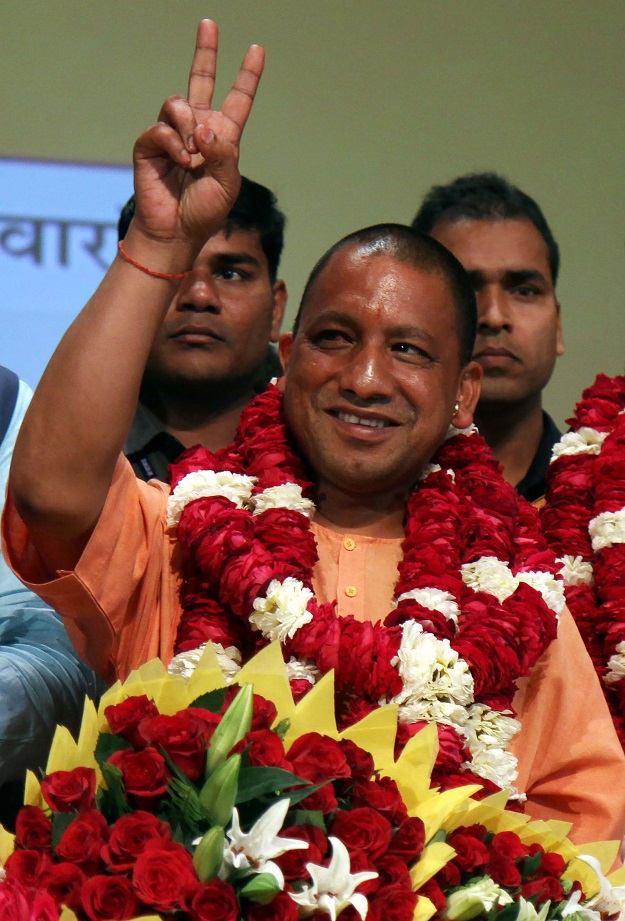In this photograph taken on March 18, 2017, new Chief Minister of the northern Indian state of Uttar Pradesh Yogi Adityanath gestures to supporters as he is presented with a floral bouquet during a ceremony in Lucknow. PHOTO: AFP