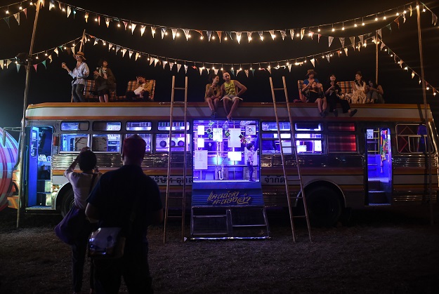 Festivalgoers sitting on top of the Molam Bus at the Wonderfruit music festival in Chonburi. PHOTO: AFP