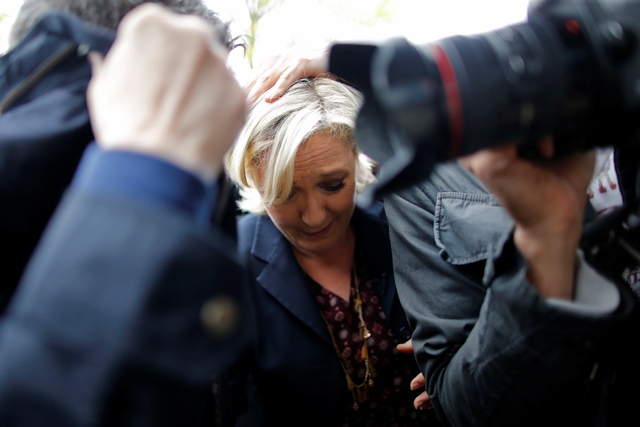Marine Le Pen, French National Front (FN) party candidate for 2017 presidential election, is protected by bodyguards as eggs are thrown by demonstrators during her arrival in Dol-de-Bretagne, France, May 4, 2017. PHOTO: REUTERS