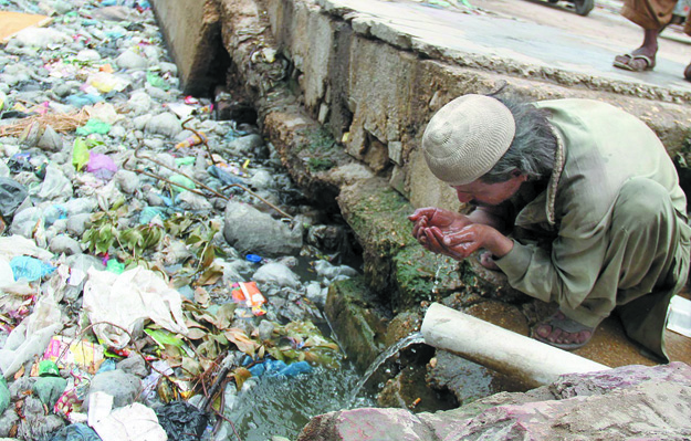 A man drinks water from a pipe installed in a sewage drain near Hyderabad Railway Station. The SC constituted the commission to probe the issue of non-provision of drinking water and sanitation in Sindh. PHOTO: ONLINE