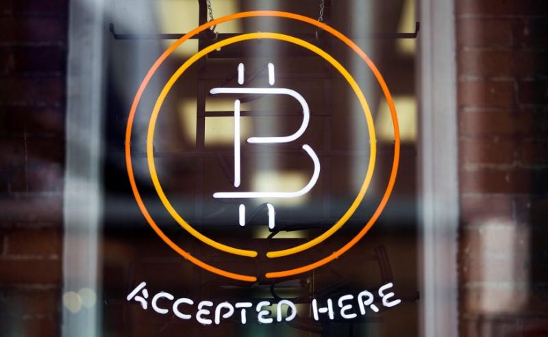 A Bitcoin sign is seen in a window in Toronto, Canada, May 8, 2014. PHOTO: REUTERS