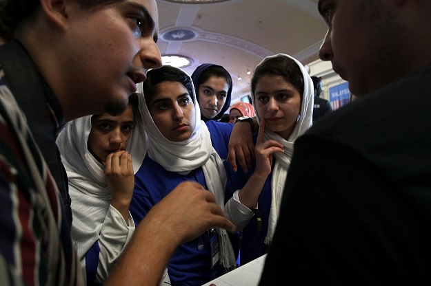Somayeh Faruqi, Lida Azizi, Yasimin Yasinzadah, and Kawsar Roshan of Team Afghanistan listen, through embassy staff Mojib Ghaznawi’s (L) translation, as they discuss strategy with a member of Team North America. PHOTO: AFP