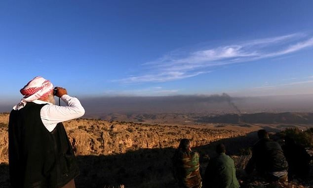 A Yazidi man watches on as Kurdish forces battle to end the Islamic State group's brutal rule over the Iraqi town of Sinjar. PHOTO: AFP