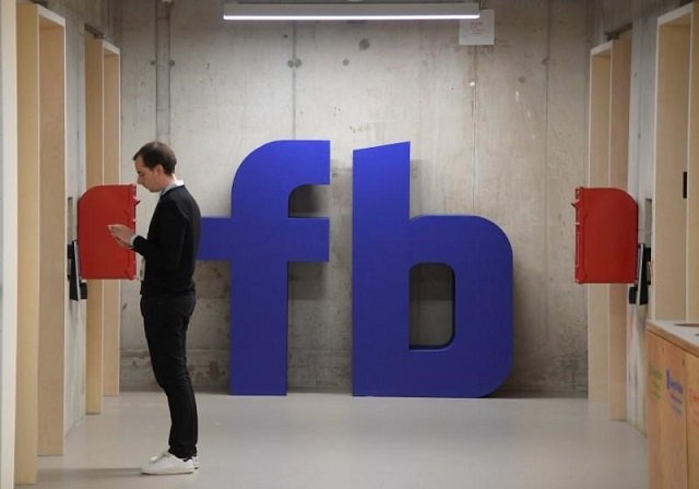 A man waits for an elevator in front of a logo at Facebook's headquarters in London, Britain, December 4, 2017.
PHOTO: REUTERS