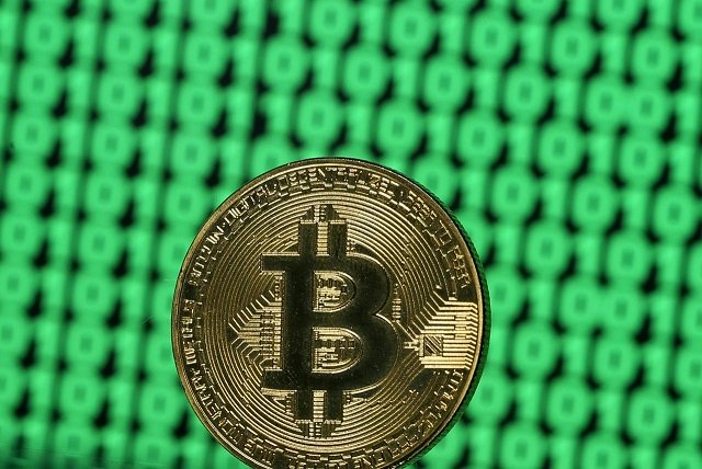 A token of the virtual currency Bitcoin is seen placed on a monitor that displays binary digits in this illustration picture, December 8, 2017.
PHOTO: REUTERS