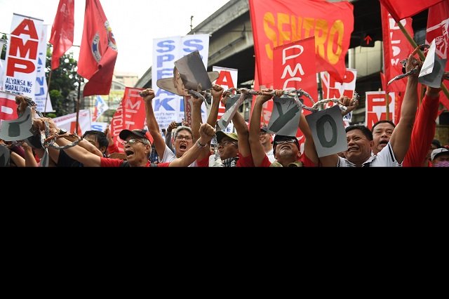 Activists along with workers break a mock chain during the May Day rally near Malacanang Palace
PHOTO: AFP
