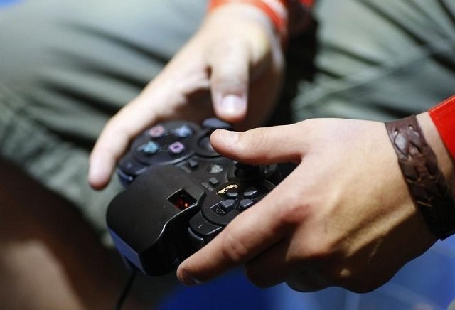 A visitor plays with a 'Playstation' at an exhibition stand at the Gamescom 2009 fair in Cologne August 22, 2009.
PHOTO: REUTERS