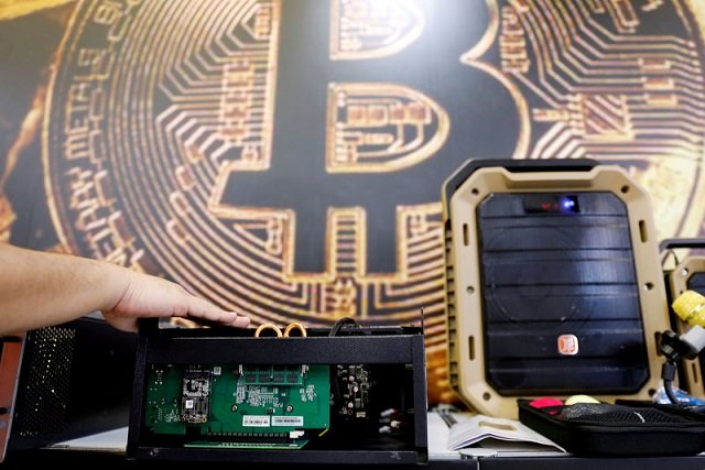 A cryptocurrency mining computer is seen in front of bitcoin logo during the annual Computex computer exhibition in Taipei, Taiwan, June 5, 2018. PHOTO: REUTERS
