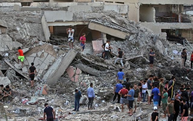 Iraqis inspect the aftermath of an explosion in an arms depot in Baghdad's Sadr City district on June 7, 2018 that killed at least 16 people. PHOTO: AFP