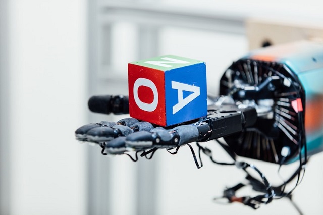 A lettered, multi-colored block rests on a human-like robotic hand in this undated handout photo.
PHOTO: REUTERS