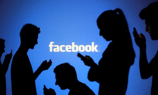 People are silhouetted as they pose with mobile devices in front of a screen projected with a Facebook logo, in this picture illustration taken in Zenica, October 29, 2014.
PHOTO: REUTERS