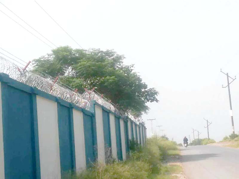 Power lines pass over the boundary wall of a school in Bani Gala. PHOTO: EXPRESS