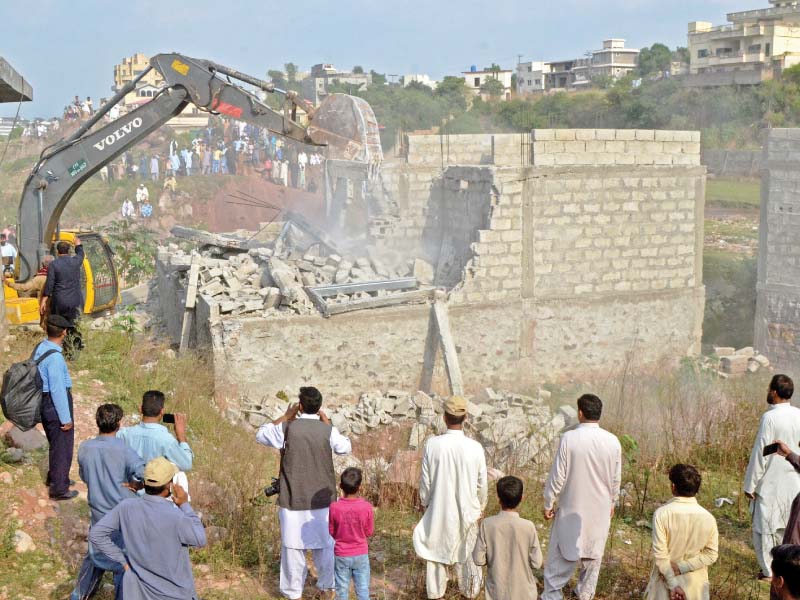 CDA employees use excavators to demolish illegal structures along Korang Nullah. PHOTO: WASEEM NAZIR/EXPRESS