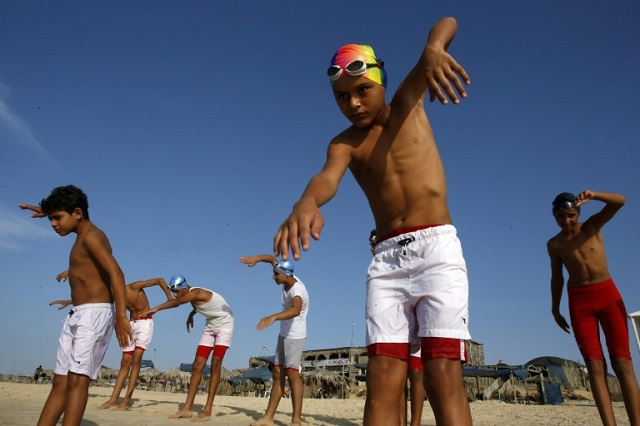 Young members of a Palestinian swimming club excercise on a beach during a training session in Beit Lahia in the northern Gaza Strip, on October 4, 2018. PHOTO: AFP