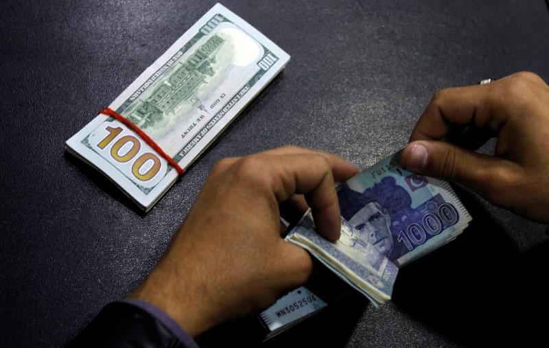 A currency trader counts Pakistani Rupee notes. PHOTO: REUTERS