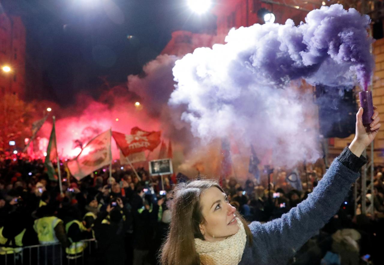 Anna Donath, Vice President of the opposition party Momentum Movement, holds a flare during a protest against a proposed new labor law, billed as the "slave law", in Budapest, Hungary. PHOTO: REUTERS
