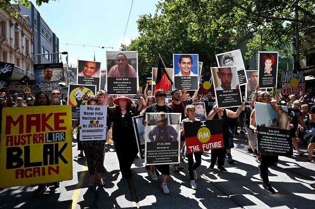 People hold up placards of Aboriginal people who have allegedly died in police custody, as they take part in an "Invasion Day" rally on Australia Day in Melbourne on January 26, 2019. PHOTO: AFP