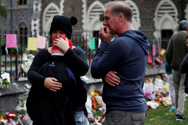 People react at a flower tribute area at Botanical Gardens in Christchurch, New Zealand. PHOTO: REUTERS
