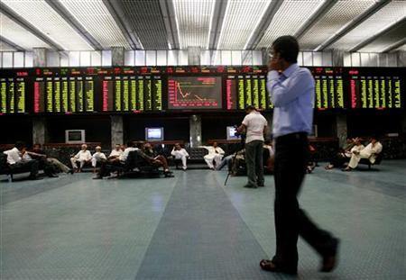 A stockbroker walks near an electronic stock exchange board inside the trading hall at the PSE. PHOTO: REUTERS