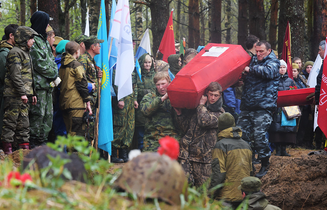 Members of volunteer search groups carry coffins with the remains of Red Army soldiers killed in World War Two, into a mass grave during a reburial ceremony at the Sinyavino Heights memorial site outside Saint Petersburg. PHOTO: AFP