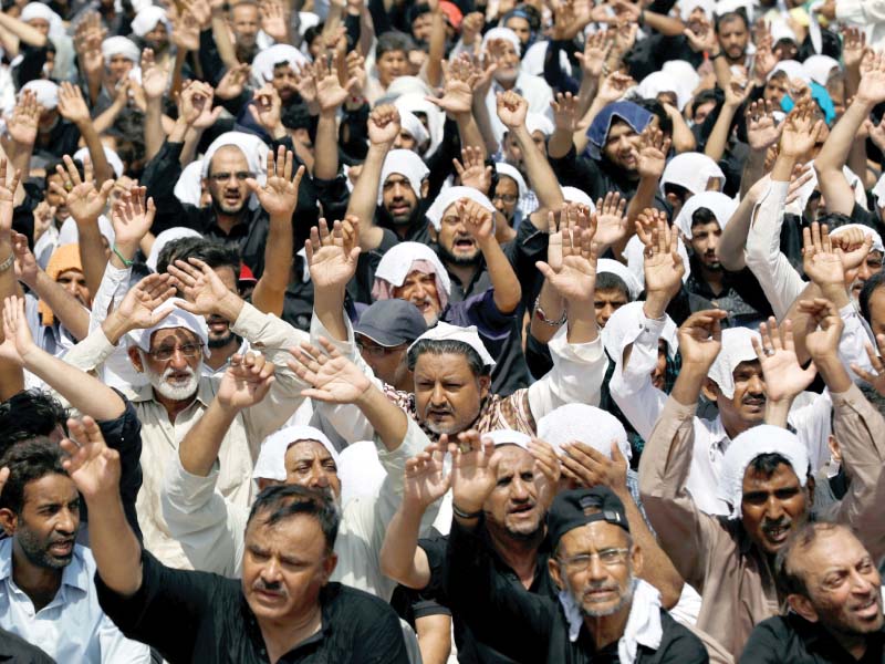 Mourners raise their hands and shout slogans during a procession on Youm-e-Ali in Karachi. The day marks the martyrdom of Hazrat Ali Ibn Abu Talib (RA). PHOTO: REUTERS