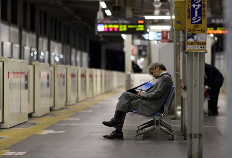 A businessman is seen napping on a bench at a Tokyo train station. PHOTO AFP