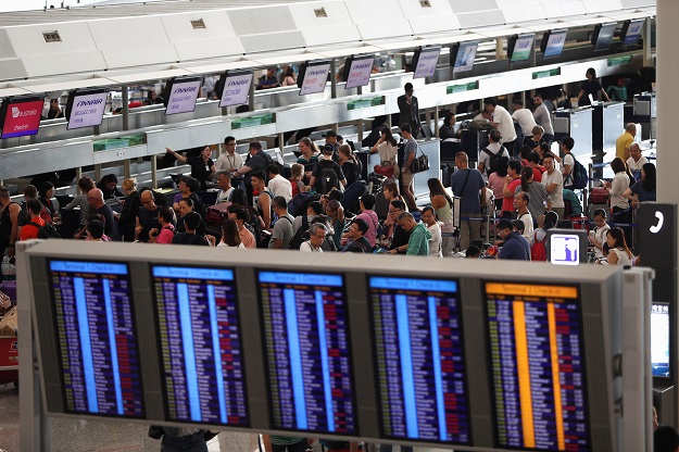 Passengers queue at check-in counters as the airport reopened a day after flights were halted due to a protest, at Hong Kong International Airport, China. PHOTO: REUTERS