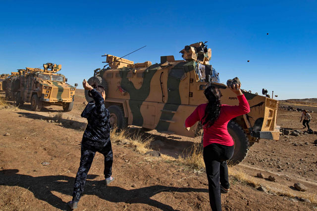 Kurdish demonstrators hurl rocks at a Turkish military vehicle on November 8, 2019, during a joint Turkish-Russian patrol near the town of Al-Muabbadah in the northeastern part of Hassakah on the Syrian border with Turkey. PHOTO: AFP