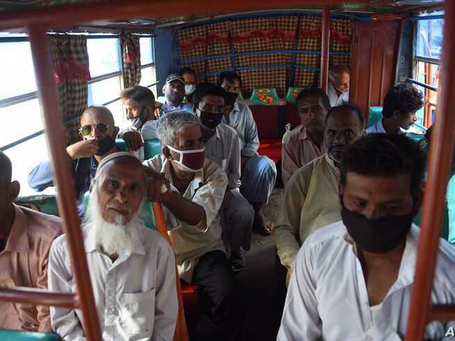 People sit in a mini bus after the government resumed public transport services in Karachi. PHOTO: AFP/FILE