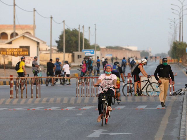 Police officers guard a street with barriers after the government announced to re-impose lockdowns in selected areas to curb coronavirus in Karach. PHOTO: REUTERS/FILE