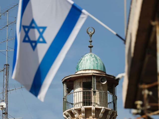 An Israeli flag waves in front of the minaret of a mosque in the Arab quarter of Jerusalem's Old City, November 14. Israeli Prime Minister Benjamin Netanyahu said he backed a bill limiting the volume of calls to prayer from mosques, a proposal government watchdogs called a threat to religious freedom.