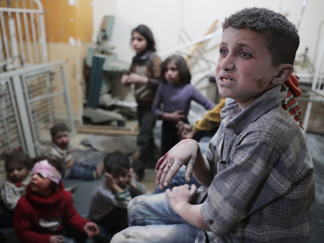 Syrian children wait to receive treatment at a makeshift clinic following reported air strikes by government forces in the rebel-held town of Douma, on the eastern outskirts of Damascus. PHOTO: AFP