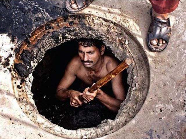 Sanitary worker taking garbage out of the gutter with no safety equipment. PHOTO: WORLDWATCHMONITOR