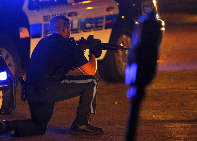 A police officer points his rifle at a man (not pictured) on the ground following the shooting of a police officer at the Massachusetts Institute of Technology (MIT). PHOTO: REUTERS