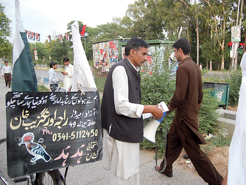 Khan has been running his campaign all by the himself and he uses his bicycle to spread his message. PHOTO: MUHAMMAD JAVAID/EXPRESS