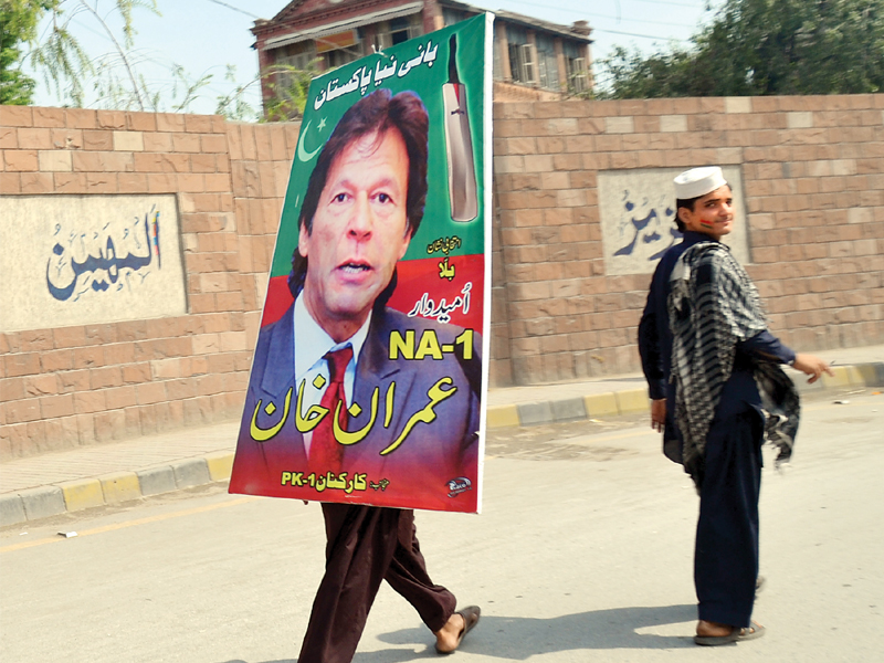 With the elections over, scrap dealers are busy removing party posters and flags put up by candidates. PHOTO: SAMIR RAZIQ