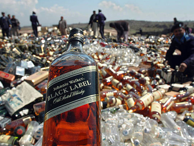 Pakistani Customs officials prepare destroy seized liquor on the outskirt of Islamabad, 14 March 2007. Pakistani Customs Collectorate destroyed thousands of illicit liquor bottles smuggled into the country. Prohibition has been enforced in the Islamic republic since the 1970s but clandestine production of alcohol is rampant especially in the rural areas. Officially two breweries operate in the country to provide liquor to non-Muslim communities, who form three percent of the 150-million-member Muslim state. PHOTO: GETTY