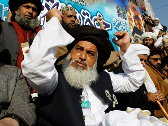 Khadim Hussain Rizvi (C), leader of Tehrik-e-Labaik Pakistan political party, raises his arms as supporters chant slogans at their protest site at Faizabad junction in Islamabad, Pakistan on November 27, 2017. PHOTO: REUTERS