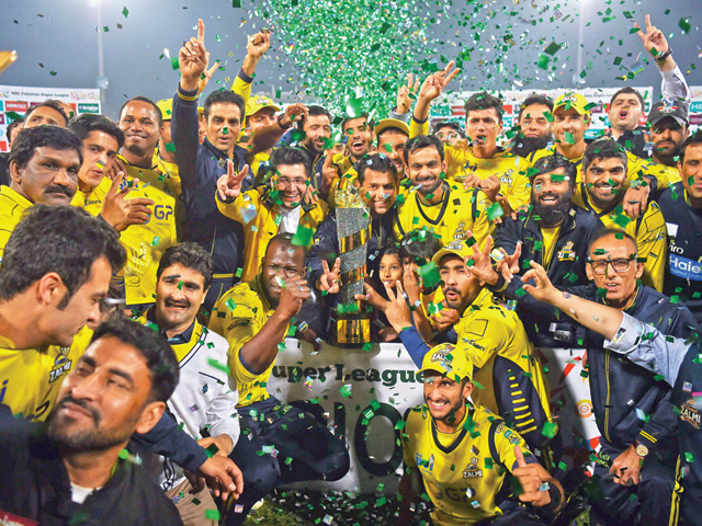 Jubilant Peshawar Zalmi players pose with the PSL trophy in Lahore. PHOTO: AFP